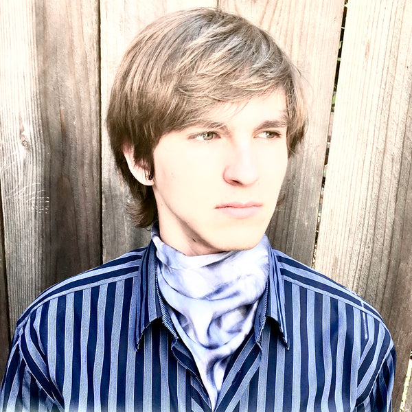Model is wearing Indigo blue luxury silk pocket square scarf in striped shibori pattern tied around neck, sustainable wear with many style looks. Best fashion accessory for any season or occasion. Makes a great gift. Handmade one of a kind artisan accessories. Square shaped 17 inches by 17 inches.
