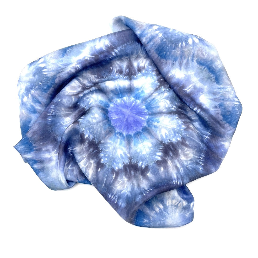 Square blue and white silk scarf measuring 30 inches by 30 inches featuring a geometric eight point circular kaleidoscope pattern. 