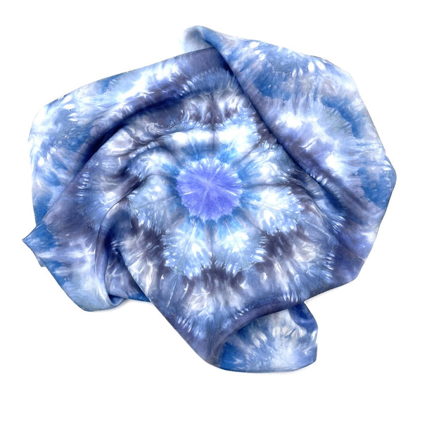 Square blue and white silk scarf measuring 30 inches by 30 inches featuring a geometric eight point circular kaleidoscope pattern. 