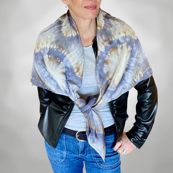 Model wearing a handmade Tie-dye shibori patterned silk shawl with kaleidoscope mandala design in shades of gray and beige on a white background.