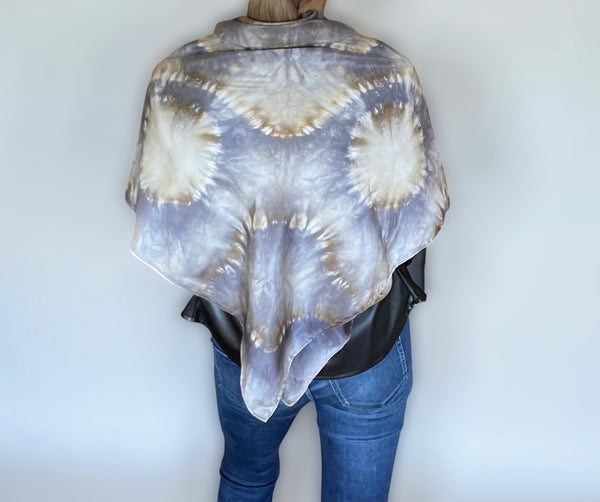 Model wearing a handmade Tie-dye shibori patterned silk shawl with kaleidoscope mandala design in shades of gray and beige on a white background.